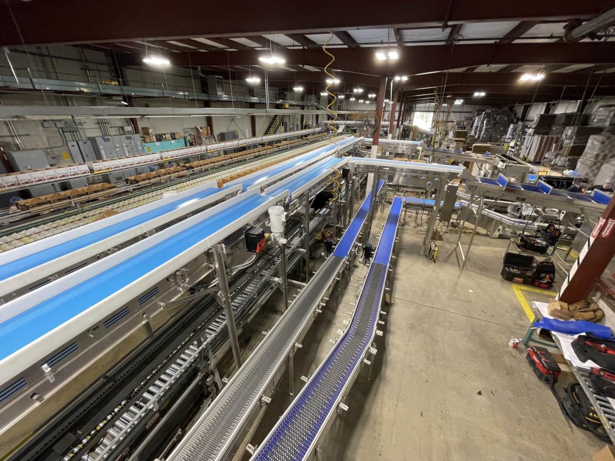 Roller conveyor system carrying boxes through a production facility